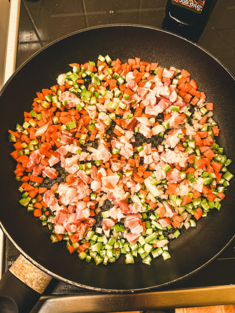 Soffritto und Pancetta in die Pfanne geben